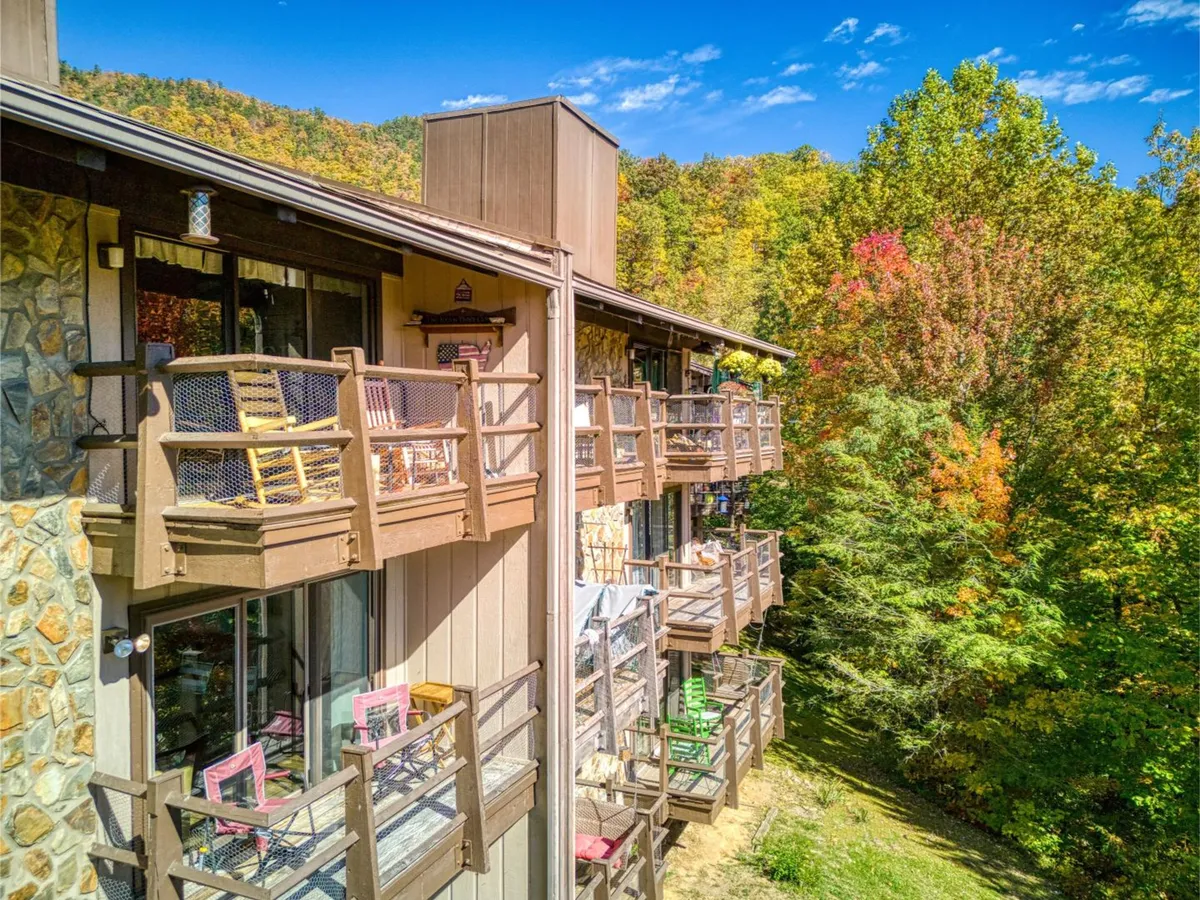 This image features condo balconies overlooking surrounding trees, with the stone facade hinting at a cozy, inviting environment. The balconies offer spaces for relaxing, watching sunsets, or gathering before heading out to local attractions.
